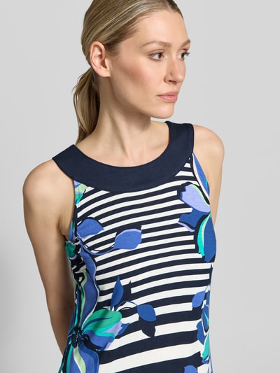 Frauenmodel trägt Knielanges Kleid aus Viskose-Mix mit Rundhalsausschnitt von Betty Barclay, navy-weiße Streifen, florale Muster, Nahaufnahme Oberkörper. Brustweite 43 cm, Stretch-Anteil, Straight Fit.