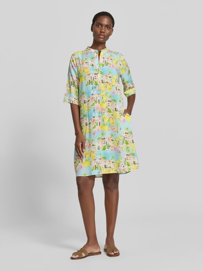 Frauenmodel trägt Knielanges Kleid aus Viskose mit 3/4-Arm von Emily Van den Bergh, Gerader-Schnitt, bunte Muster, Ganzkörperansicht von vorne, Rückenlänge 96 cm, Brustweite 50 cm, Ärmellänge 36 cm.