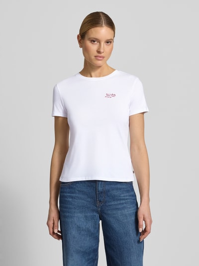 Kobiece model prezentuje Regular Fit T-Shirt aus reiner Baumwolle od Tom Tailor Denim, efekt: jednolity kolor, wyhaftowany napis, okrągły dekolt, krótki rękaw, wykończenie materiału: dżersej, materiał: bawełna, Ganzkörperansicht von vorne.