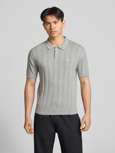Männermodel trägt Slim Fit Strick-Poloshirt mit Label-Stitching von REVIEW in Grau mit Zopfmuster, Reine Baumwolle, Knopfleiste, Ganzkörperansicht von vorne.
