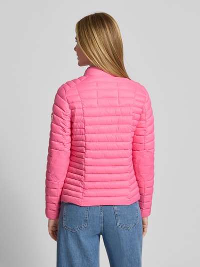Modelka nosi Kurtkę pikowaną z zamkiem błyskawicznym dwustronnym model 'JUDY' od Frieda & Freddies, kolor różowy, krój slim fit, stójka, kieszenie zapinane na zamek błyskawiczny, długość tyłu w rozmiarze 36: 57 cm, szerokość ramion w rozmiarze 36: 40 cm, szerokość klatki piersiowej w rozmiarze 36: 48 cm, długość rękawów w rozmiarze 36: 64 cm, widok całej sylwetki od tyłu