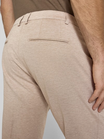 Mężczyzna nosi Regular Fit Hose aus Viskose-Mix Modell 'CISALTO' von CINQUE, beżowy kolor, tekstura gładka, z tylnymi kieszeniami, Szerokość w rozmiarze 50: 46 cm, długość nogawki: 75 cm, detaliczne ujęcie tyłu.
