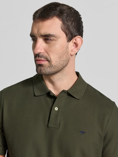 Männermodel trägt Regular Fit Poloshirt mit Label-Stitching von Fynch-Hatton in Olivgrün, reine Baumwolle, Nahaufnahme Oberkörper.