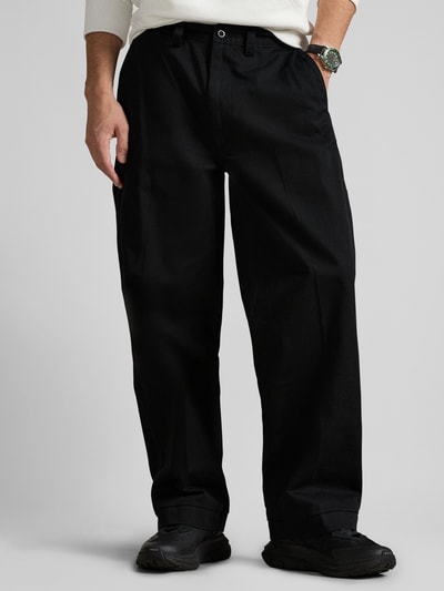 Mężczyznamodel nosi Regular Fit Weite Hose aus reiner Baumwolle von Polo Ralph Lauren, czarna, gładka bawełna, krój regular fit, naszywka z logo, szlufki, zapięcie na guzik i kryty zamek, kieszenie tylne i boczne, Ganzkörperansicht z przodu.