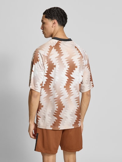 Männermodel trägt Regular Fit T-Shirt mit Allover-Muster von adidas Sportswear, Label-Print, Rundhals, Kurzarm, Ganzkörperansicht Rückansicht.