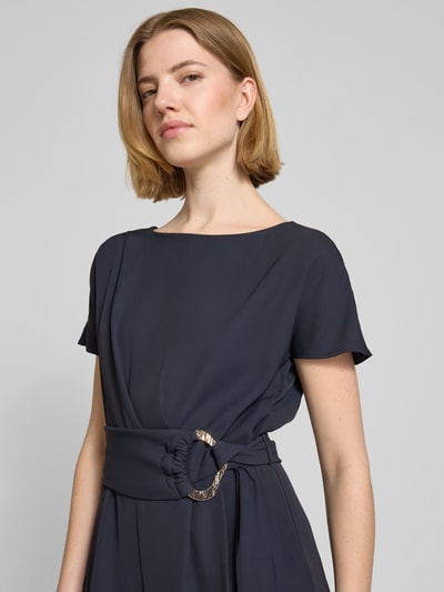 Vrouwenmodel draagt Jumpsuit met Stretch-Anteil van Betty Barclay in navy, regular fit, ronde hals, korte mouw, riem in taille, elastische materiaalmix, geplooide details, detailopname bovenlichaam.