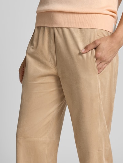 Frauenmodel trägt Stoffhose mit Stretch-Anteil von Marc Cain in Beige mit Ziernähten, elastischem Bund und Balloon Fit, Nahaufnahme Oberkörper.