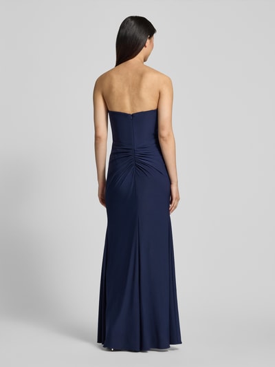 Frauenmodel trägt Slim Fit Abendkleid in Maxilänge mit Gehschlitz von Hey Kyla aus Elastischer-Material-Mix in Dunkelblau, Raffung, Schulterfrei, Ganzkörperansicht Rückansicht. Rückenlänge: 132 cm, Brustweite: 28 cm bei Größe 36.