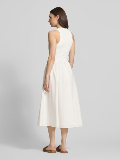 Vrouwenmodel draagt Midikleid aus reiner Baumwolle van Tommy Jeans in effen wit, a-lijn pasvorm, mouwloos, ronde hals, midi-lengte. Ganzlichaamsaanzicht achteraan.