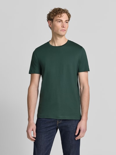 Męski model trägt T-Shirt aus Baumwolle mit Rundhalsausschnitt von Christian Berg Men, krój slim fit, ciemnozielony, długość tyłu 73 cm, Ganzkörperansicht von vorne.
