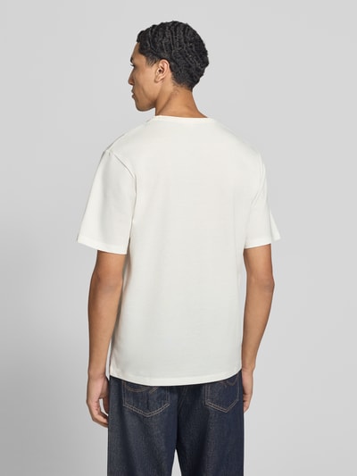 Männermodel trägt Regular Fit T-Shirt aus Baumwoll-Mix Modell 'Alves' von JACK & JONES in Weiß, glatte Struktur, Ganzkörperansicht Rückansicht. Rückenlänge bei Größe M 70 cm, dezentes Logo-Detail, Rundhalsausschnitt.