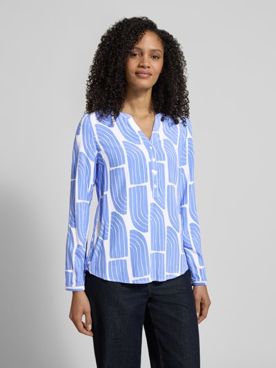 Frauenmodel trägt Wellen-Print Schlupfbluse aus Viskose von Christian Berg Woman, weiß-blau gemustert, Regular Fit, Ganzkörperansicht von vorne.