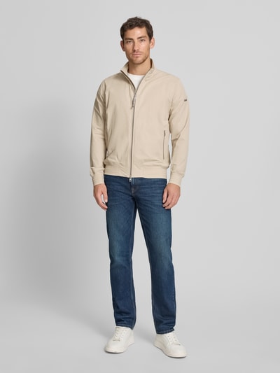 Männermodel trägt Blouson mit Zweiwege-Reißverschluss Modell 'SCRIP' von CINQUE in Beige, Baumwoll-Mix mit Stretch-Anteil, Regular-Fit, Stehkragen, Ganzkörperansicht von vorne.