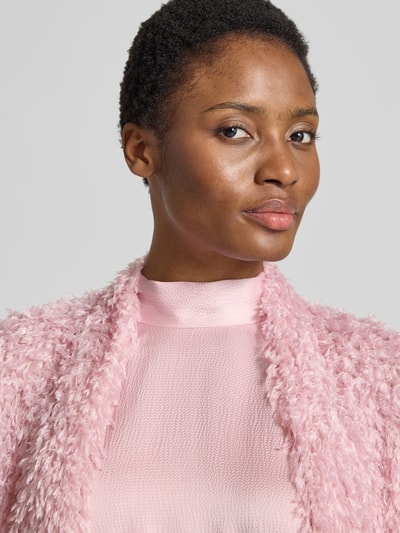Frauenmodel trägt Cropped Jacke aus Effektgarn mit V-Ausschnitt von SWING in Rosa, Struktur und Slim Fit, Nahaufnahme Oberkörper.