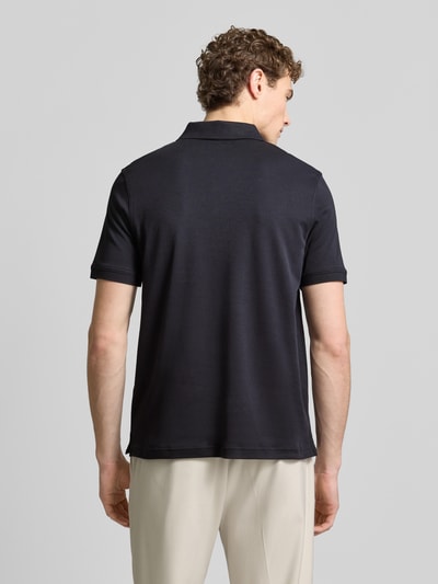 Männermodel trägt Regular Fit Poloshirt mit Logo-Stitching von Fynch-Hatton in Schwarz, reine Baumwolle, Rückenansicht, Ganzkörperansicht.