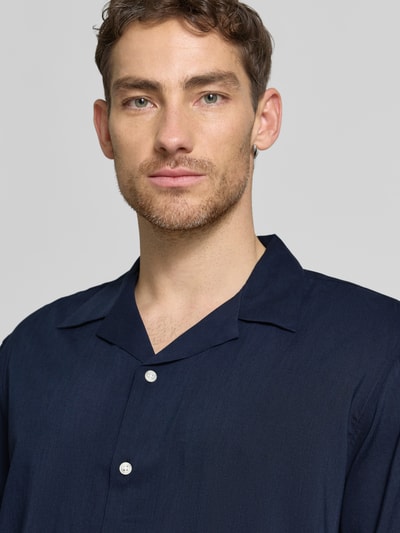 Männermodel trägt Relaxed Fit Freizeithemd aus Bio-Baumwoll-Modal-Mix Modell 'RELAXAIR' von SELECTED HOMME, Optik: Unifarben, Knopfleiste: durchgehend, Reverskragen, Ärmelform: Kurzarm; Nahaufnahme Oberkörper.