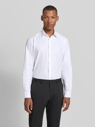 Männermodel trägt Slim Fit Business-Hemd mit Kentkragen von Jake*s, biała bawełna, krój slim fit, zaokrąglony dół, długość pleców 79 cm, szerokość w rozmiarze 39/40: 48 cm, długość rękawa 65 cm, widok całej sylwetki z przodu