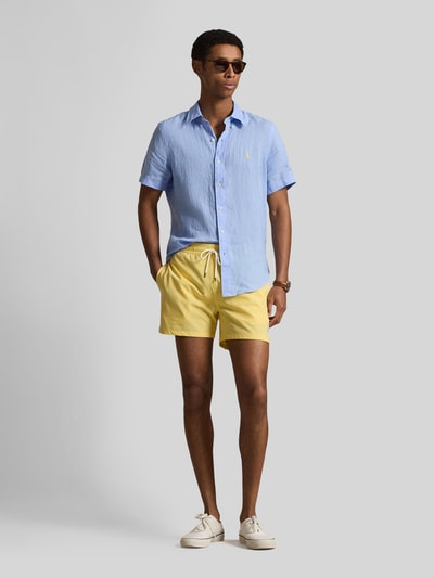 Männermodel trägt Regular Fit Leinenhemd mit Button-Down-Kragen van Polo Ralph Lauren, lichtblauw, unicolor, kortemouw, puur linnen, logo-detail, afgeronde zoom, voorkant vollichaam.