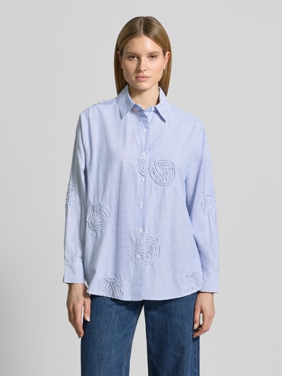 Frauenmodel trägt Relaxed Fit Bluse mit Streifenmuster Modell 'Dalma Dori' von Neo Noir aus reiner Baumwolle, florale Applikationen, Hemdblusenkragen, Ganzkörperansicht von vorne.