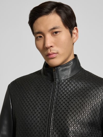 Männermodel trägt Lederjacke aus Lammleder mit Eingrifftaschen von Emporio Armani in Schwarz, strukturierte Oberfläche, Nahaufnahme Oberkörper.