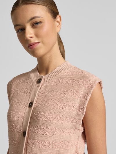 Frauenmodel trägt Strickweste mit Rundhalsausschnitt von Scotch & Soda, Baumwoll-Mix, Slim Fit, Knopfleiste, Nahaufnahme Oberkörper.