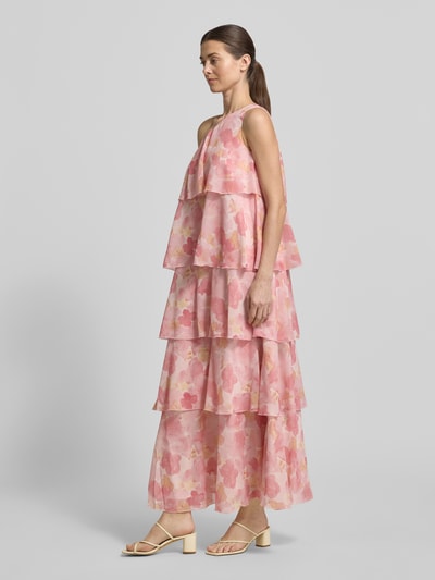 Vrouwenmodel draagt maxi-jurk Ausgestelltes Maxikleid met Rüschendetail model 'FELICIA' van Vero Moda, all-over bloemenmotief, uitlopend, maxilengte, asymmetrische hals, met ruchedetail, onderjurk, one-shoulder model, mouwloos, asymmetrisch rugdecolleté, volantzoom, chiffon materiaalverwerking, roze tinten, structuur: licht transparant met lagen, geheelbeeld van voren.