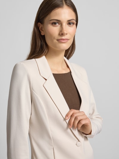 Modelka nosi Regular Fit Strickjacke mit Reißverschluss von Polo Ralph Lauren z bawełny, krój regular fit, kaptur, tunel, zamek błyskawiczny, wyhaftowane logo, wpuszczane kieszenie, prążkowane wykończenia, długość tyłu w rozmiarze S: 51 cm, szerokość w rozmiarze S: 58 cm, długość rękawów w rozmiarze S: 60 cm; jasnobeżowy, gładka struktura, proste linie; zbliżenie na górną część ciała, widok z przodu.