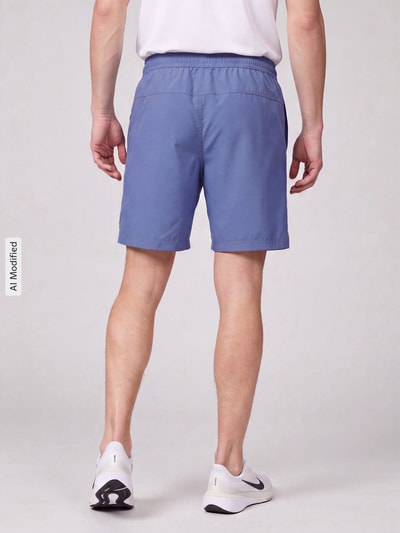 Männermodel trägt Regular Fit Sportshorts mit Logo-Print von Nike in Blau, glatte Oberfläche, Herren Sportshorts, Ganzkörperansicht Rückansicht, KI-modifiziertes Bild.