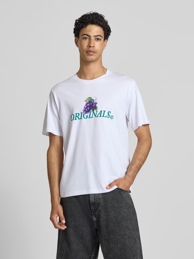 Männermodel trägt Regular Fit T-Shirt mit Statement-Print Modell 'Eres' von Jack & Jones aus reiner Baumwolle mit Rundhalsausschnitt, Ganzkörperansicht von vorne.