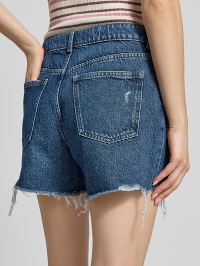 Frauenmodel trägt Jeansshorts im Used-Look und mit 5-Pocket-Design von REVIEW aus Reine Baumwolle, Loose-Fit, Ganzkörperansicht Rückansicht.