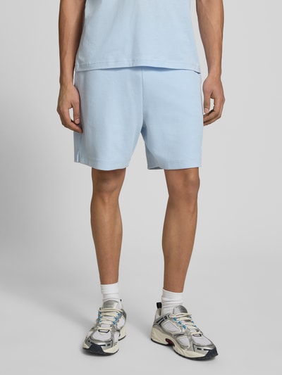 Mężczyzna nosi Regular Fit Sweatshorts aus Baumwoll-Mix Modell 'NUWAFFLO' od HUGO Blue, jasnoniebieski kolor, bawełniana faktura, krój regular fit, gładki wzór, label patch, kieszenie boczne i z tyłu, elastyczny pas, tunel, perspektywa: całkowity widok z przodu.