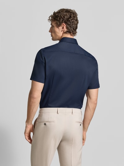 Męski model nosi Slim Fit Business-Hemd mit Kentkragen od Jake*s, granat, krótki rękaw, gładka tekstura, widok z tyłu, Ganzkörperansicht Rückansicht. Szerokość w rozmiarze 39/40: 45 cm, długość pleców: 80 cm, długość rękawa: 25 cm, elastyczny materiał, krój slim fit, kent kołnierz, zapięcie na guziki.