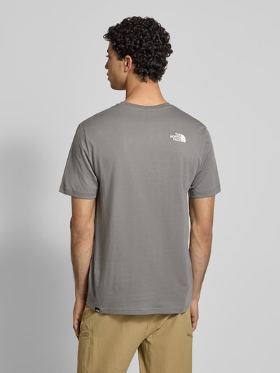 Männermodel trägt T-Shirt mit Label-Print von The North Face in Grau, Baumwoll-Mix, Regular-Fit, Rückenlänge 71 cm, Ganzkörperansicht Rückansicht.