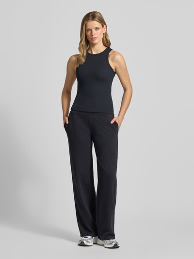 Frauenmodel trägt schwarzes Tanktop mit Feinripp von REVIEW, Baumwoll-Elasthan-Mix, körpernahe Passform, Rundhalsausschnitt, Ganzkörperansicht von vorne.