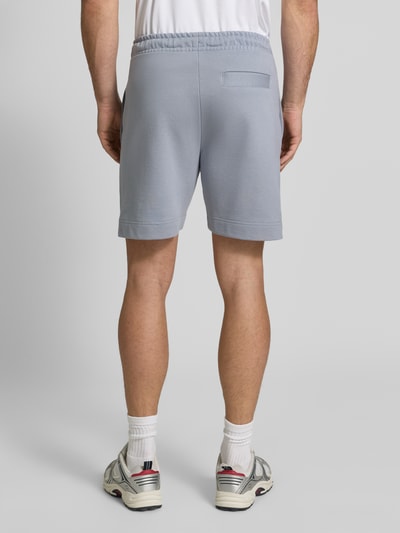 Männermodel trägt Regular Fit Sweatshorts aus Baumwoll-Mix Modell 'JT_SHORTS' von BOSS für Herren in Hellgrau, Kontext BOSS Green, Ganzkörperansicht Rückansicht.