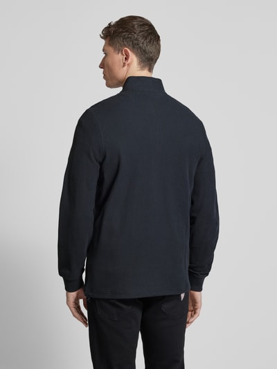Männermodel trägt Sweatjacke mit Stehkragen und Reißverschluss von camel active in Schwarz, reine Baumwolle, Regular Fit, Ganzkörperansicht Rückansicht.