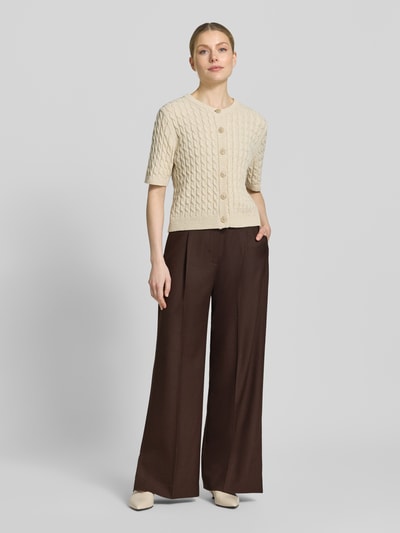 Kobiece model prezentuje spodnie z szerokimi nogawkami Wide Leg Hose mit Bügelfalten Modell 'RAVNA' od Copenhagen Muse, mieszanka materiałów z dodatkiem wiskozy, kanty, listwa guzikowa, szerokość w rozmiarze S: 39 cm, długość wewnętrzna nogawki: 80 cm, widok całej sylwetki z przodu.