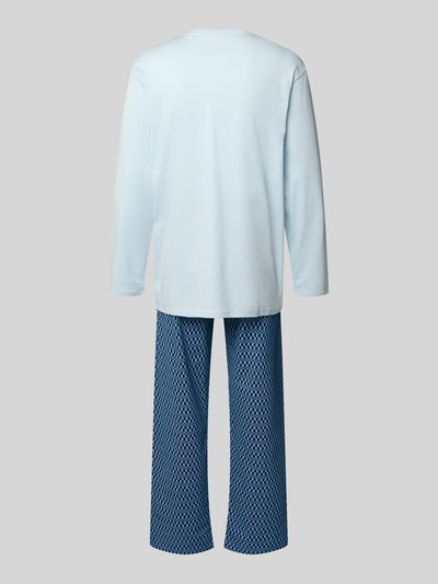 Männermodel trägt Pyjama mit klassischer Brusttasche und Rundhalsausschnitt von Schiesser, Reine Baumwolle, bequemer Schnitt, elastischer Bund, hellblaues Oberteil, gemusterte blaue Hose, Bewegungsfreiheit, Ganzkörperansicht Rückansicht.