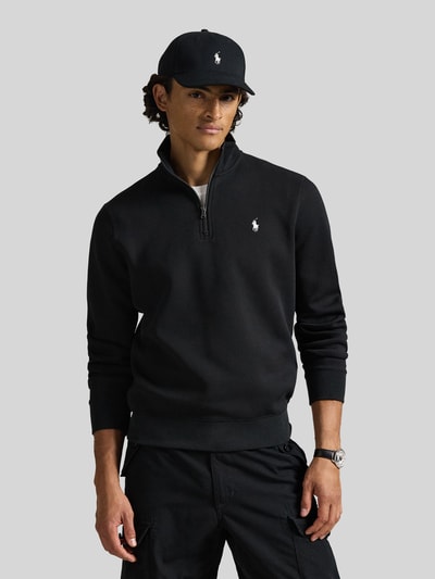Männermodel trägt schwarzen Relaxed Fit Troyer aus Baumwoll-Mix von Polo Ralph Lauren, weiße Logo-Stickerei, Nahaufnahme Oberkörper.