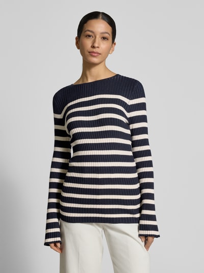 Modelka nosi Strickpullover mit Rundhalsausschnitt Modell 'DOLLIE' od Soyaconcept, dzianinowy pulower damski z mieszanki wiskozy, krój slim fit, granatowo-białe paski, przód w całości, szerokość w rozmiarze S: 63 cm, długość rękawa: 65 cm, widok całej sylwetki z przodu.