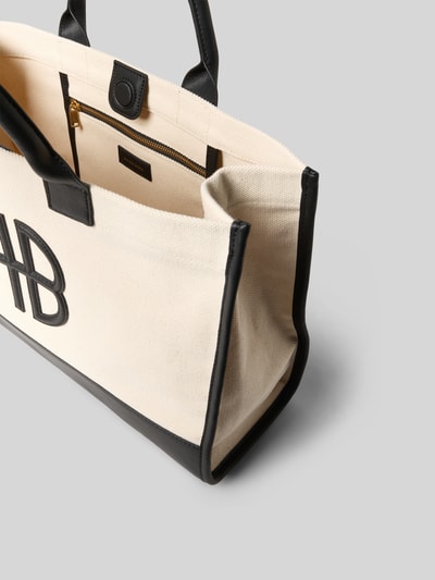 Produktfoto, Tote Bag mit Logo-Detail von Anine Bing in Beige mit schwarzem Strukturmuster, Magnetverschluss, Reißverschlussfach, abgerundete Tragehenkel, Maße ca. 49x29x13 cm