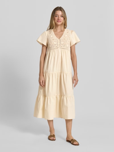 Frauenmodel trägt Midikleid im Stufen-Look mit Häkelspitze Modell 'SANDY' von Bash aus Reiner Baumwolle, A-Linie, V-Ausschnitt, Knopfleiste, Rückenlänge 120 cm, Brustweite 42 cm, Ärmellänge 20 cm; sanfte Cremefarbe, strukturierte Textur, Ganzkörperansicht von vorne.