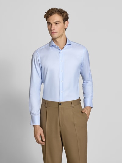 Männermodel trägt Slim Fit Business-Hemd aus reiner Baumwolle von Christian Berg Men in Hellblau, Haikragen, Knopfleiste, Ganzkörperansicht von vorne.