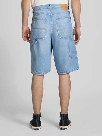 Männermodel trägt Regular Fit Jeansshorts mit Label-Details von REVIEW, hellblauer Denim, 5-Pocket-Design, Ganzkörperansicht Rückansicht.