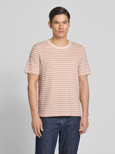 Männermodel trägt Regular Fit T-Shirt aus katoenmix Modell 'KEVIN' van SELECTED HOMME met gestreept allover-motief, fijngebreid, ronde hals, korte mouw, kleur lichtroze en beige. Ganzkörperansicht von vorne.