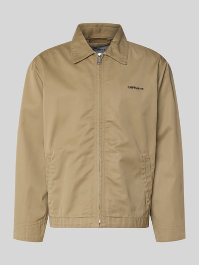 Produktfoto, Jacke mit Label-Stitching und Eingrifftaschen von Carhartt Work In Progress, kolor beżowy, zamek błyskawiczny, wykładany kołnierz, wpuszczane kieszenie, wyhaftowane logo, krój regular fit, długość tyłu w rozmiarze M: 68 cm, szerokość ramion w rozmiarze M: 59 cm, szerokość klatki piersiowej w rozmiarze M: 60 cm, długość rękawów w rozmiarze M: 20 cm