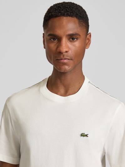 Męski model nosi Regular Fit T-Shirt aus reiner Baumwolle von Lacoste, jednokolorowy, krój regular fit, aplikacja z logo, okrągły dekolt, krótki rękaw, bawełna, nahaufnahme oberkörper.