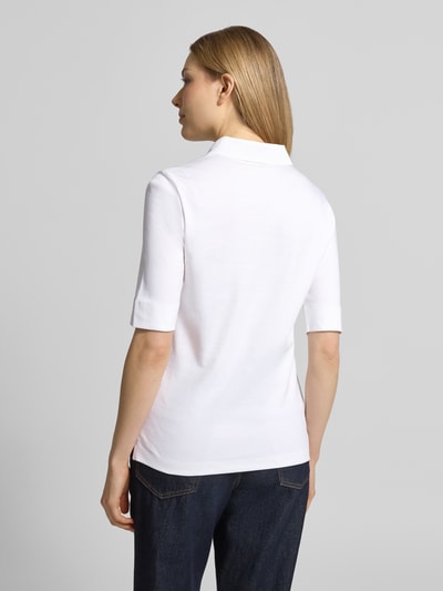 Vrouwenmodel draagt Slim Fit poloshirt met knoopsluiting en 1/2-mouwen van Christian Berg Woman, puur katoen, ruglengte maat 36: 61 cm, ganzekörperaanzicht rückenansicht.