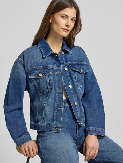 Frauenmodel trägt Regular Fit Jeansjacke aus reiner Baumwolle Modell 'GIZZIE' von HUGO, Denim-Optik, Kontrastnähte, Ganzkörperansicht von vorne.