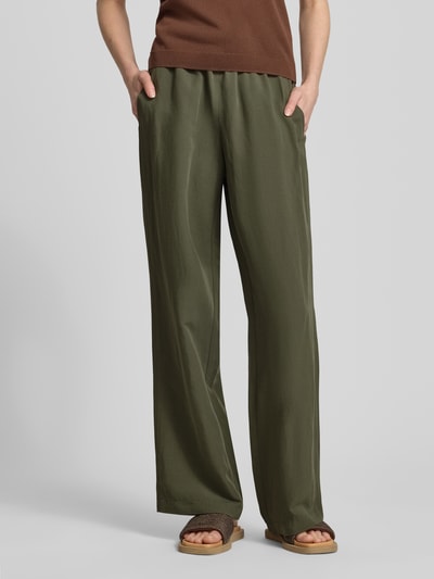 Frauenmodel trägt Leinenhose mit elastischem Bund Modell 'Roma' von STEHMANN in Olivgrün, Wide-Leg-Pants aus Leinen, Nahaufnahme Unterkörper.